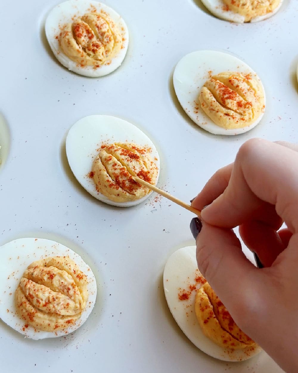 making grooves in egg yolk with toothpick.