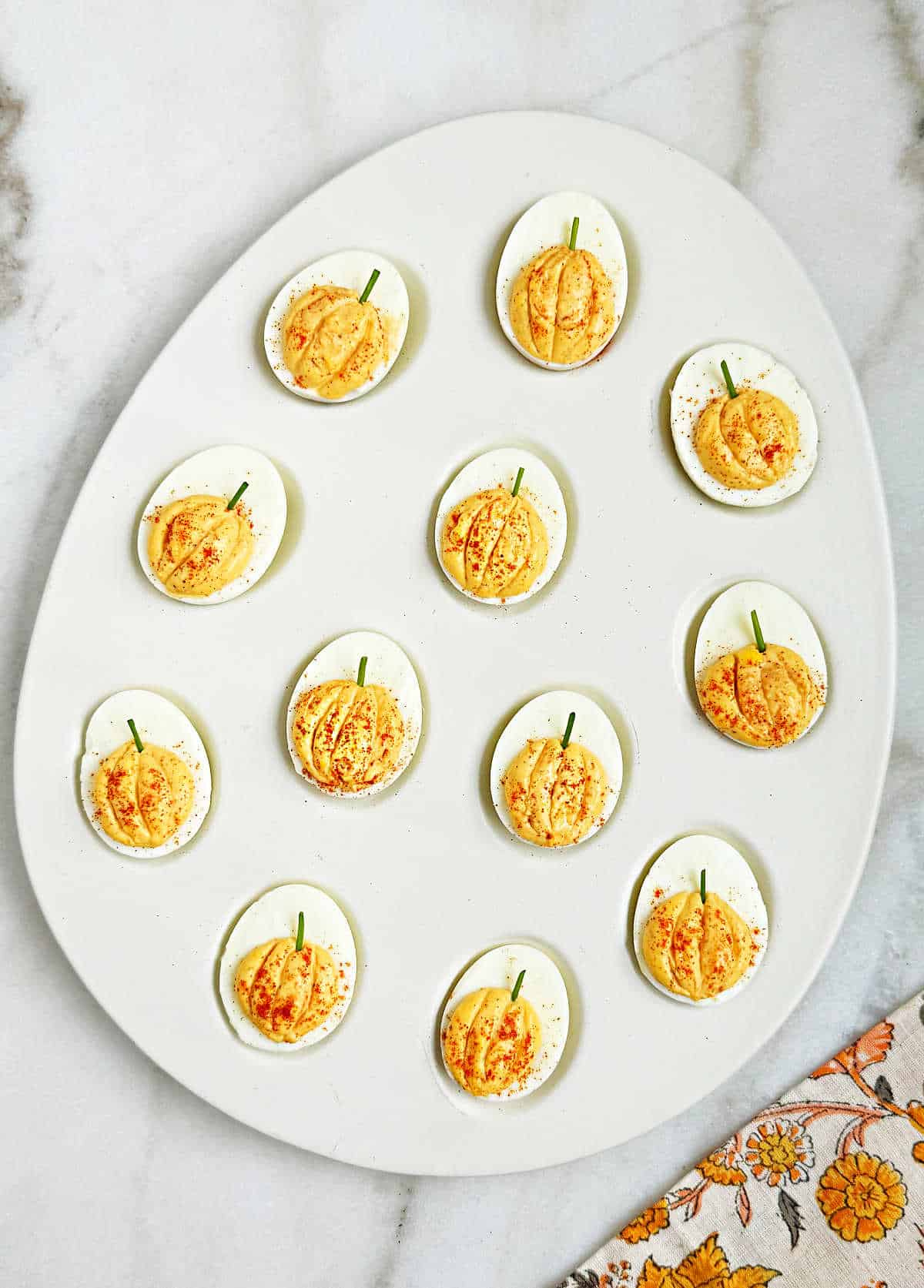 pumpkin deviled eggs in egg-shaped tray.