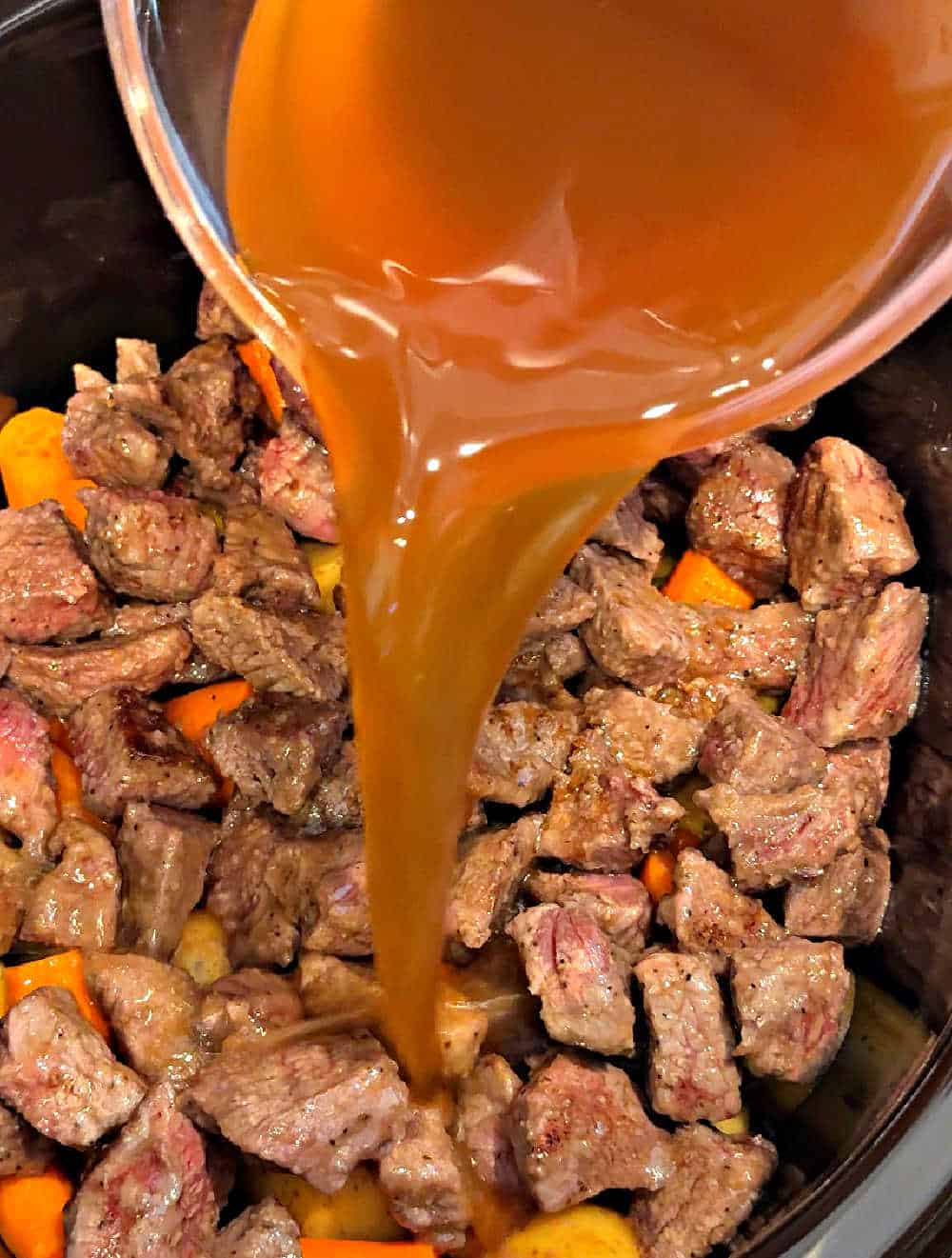pouring broth into crock pot.