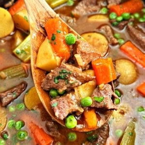 slow cooker beef stew with onion soup mix on wooden spoon.