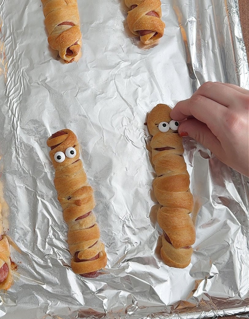 placing eyes on mummy hot dogs.