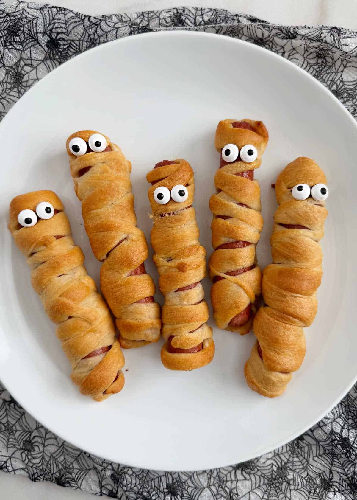 plate of mummy dogs with candy eyes.