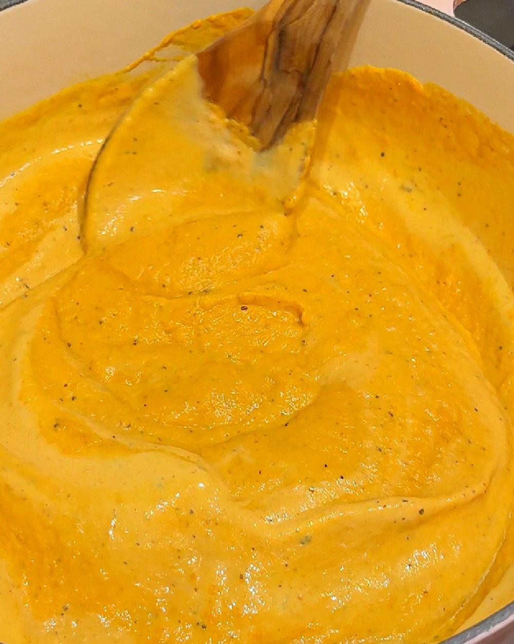 stirring cream into sauce.