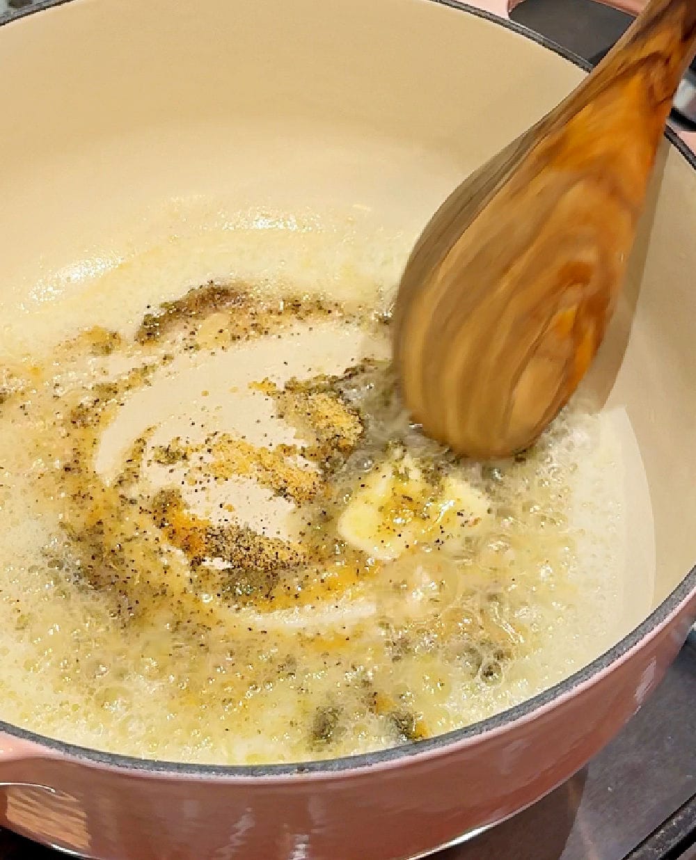 stirring butter and spices with wooden spoon.