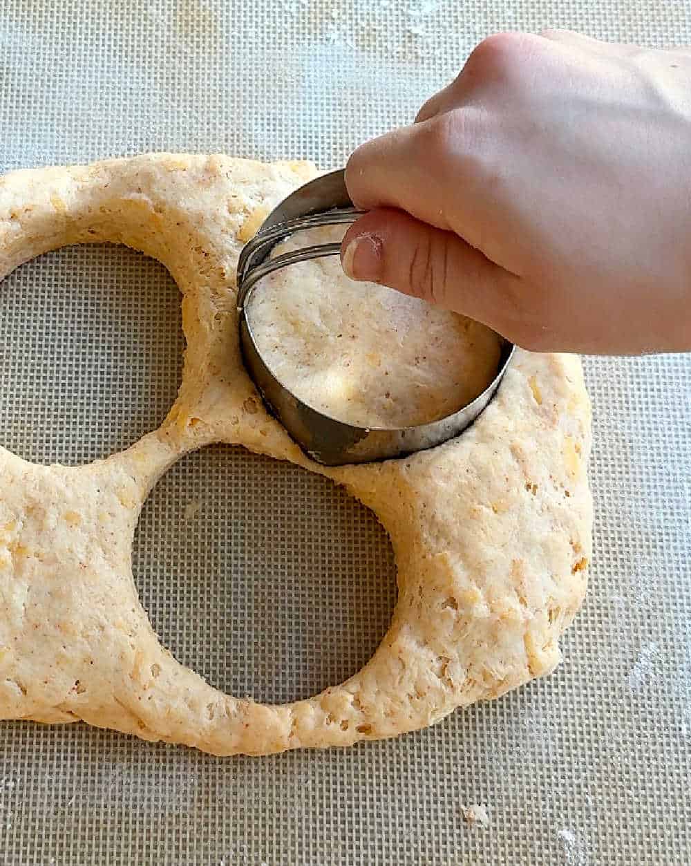 cutting dough with biscuit cutter.