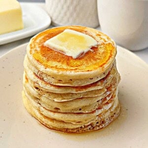 fluffy sourdough pancakes with butter and maple syrup.