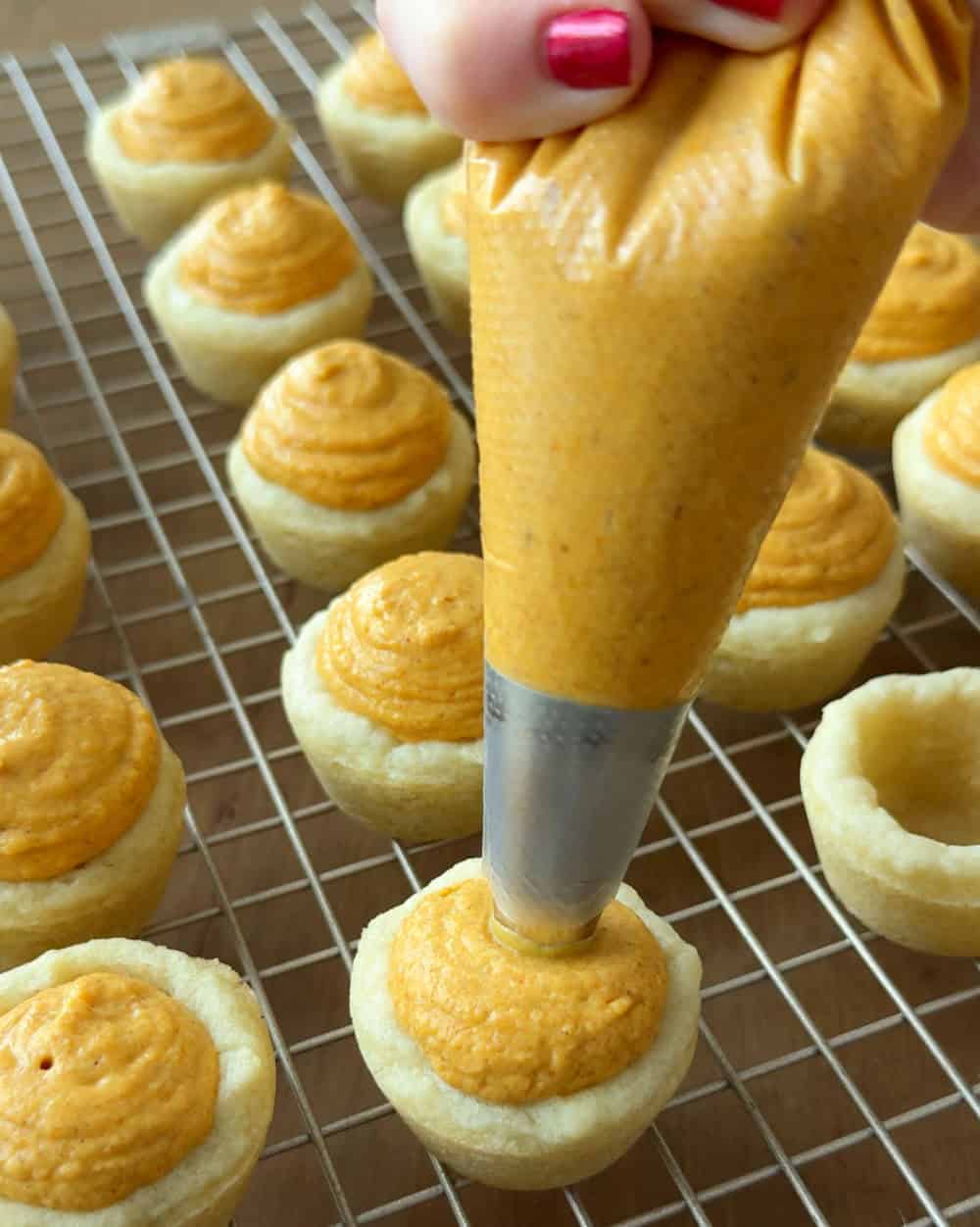 piping filling into sugar cookie cups.