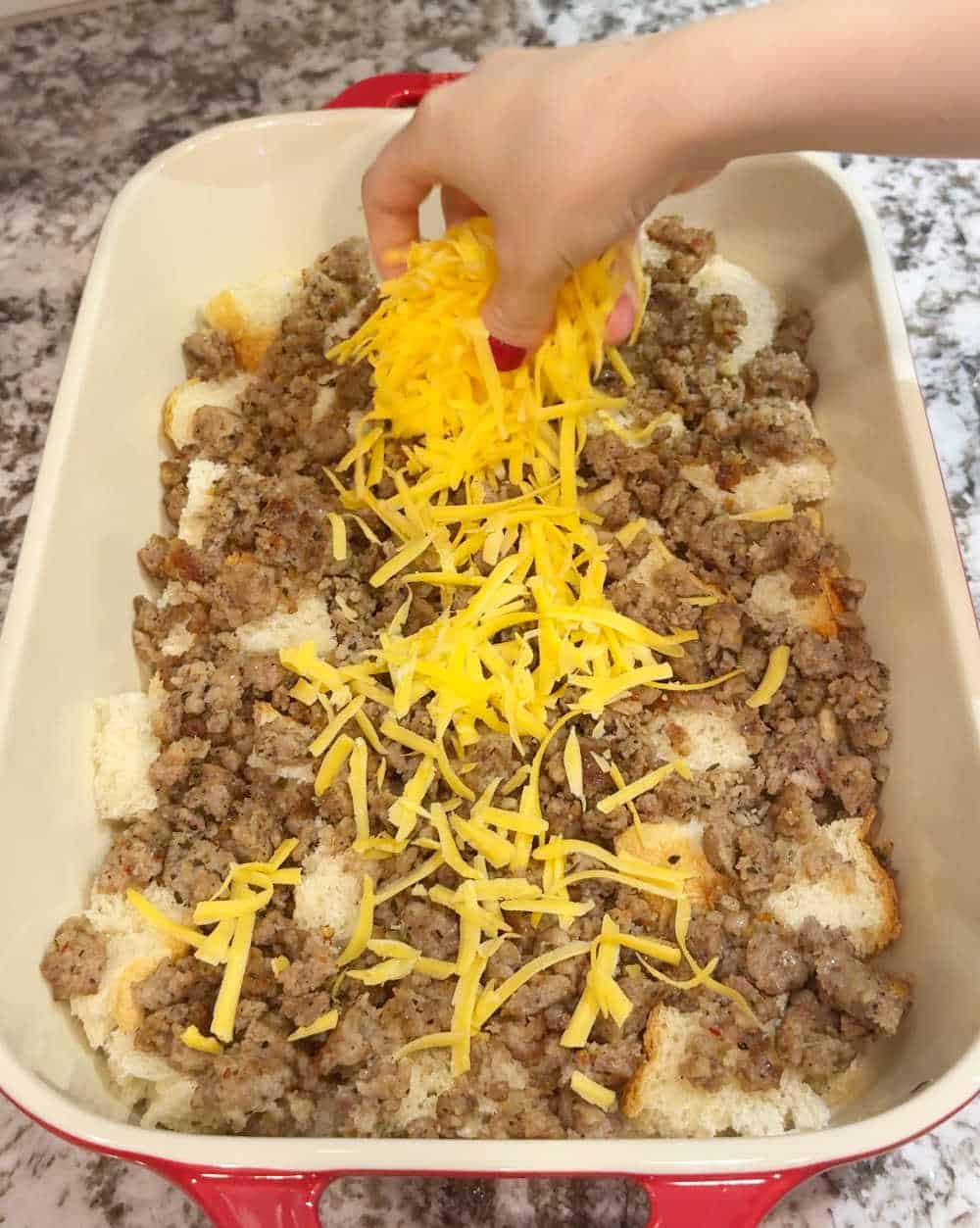 topping casserole with shredded cheese.