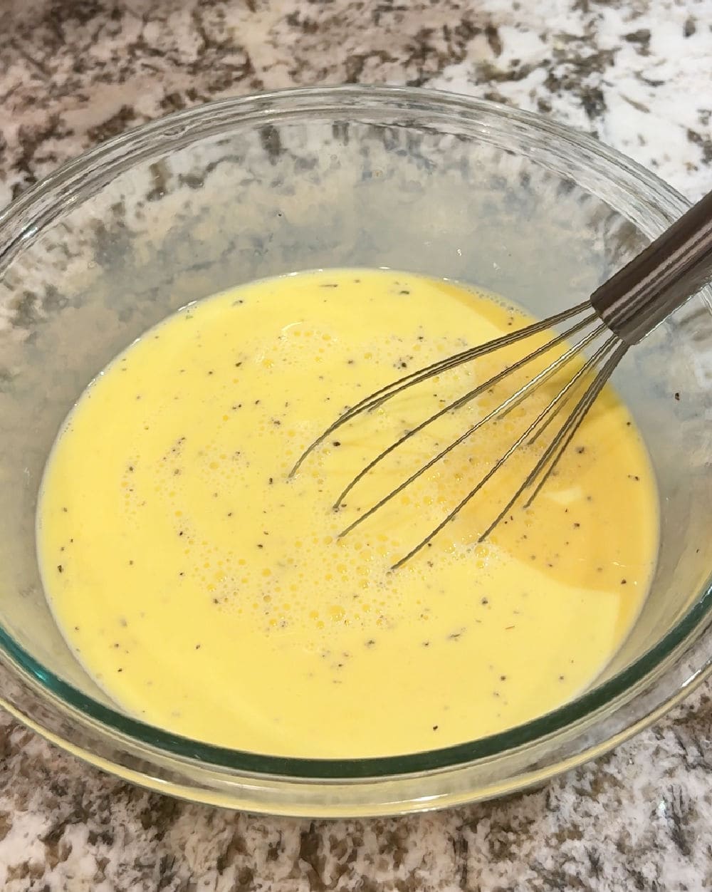 whisking egg mixture in bowl.