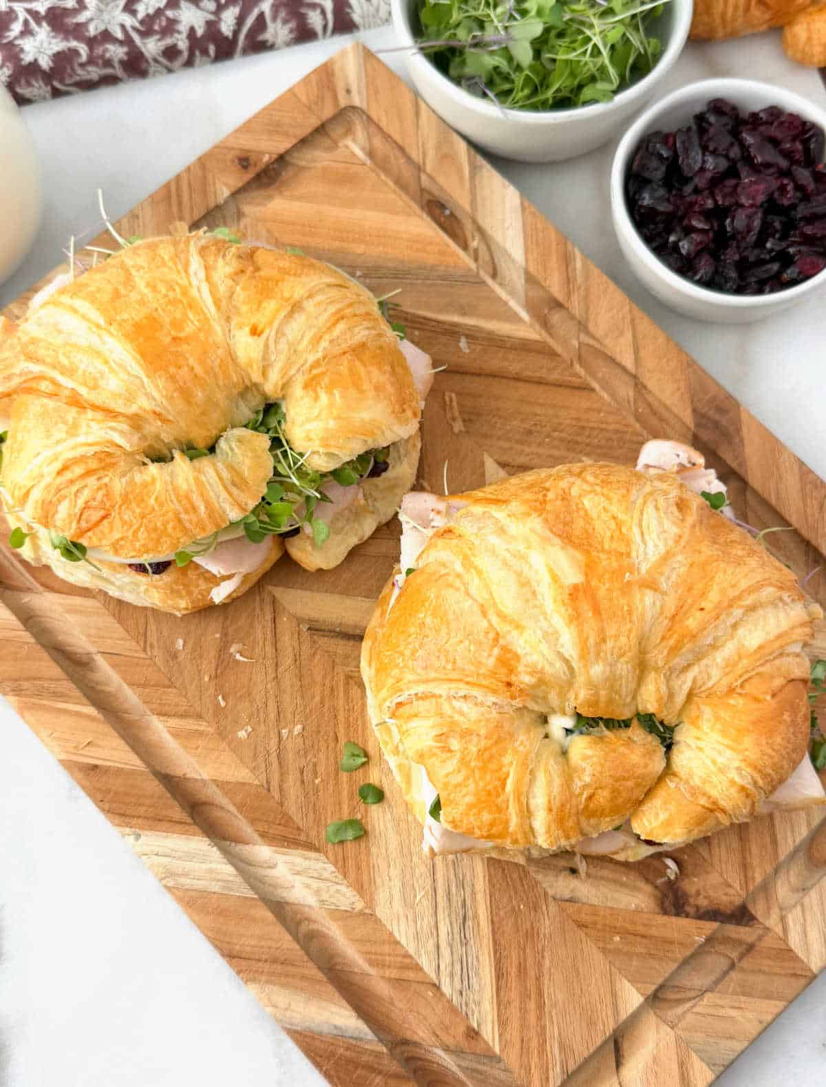turkey croissant sandwiches on a cutting board.