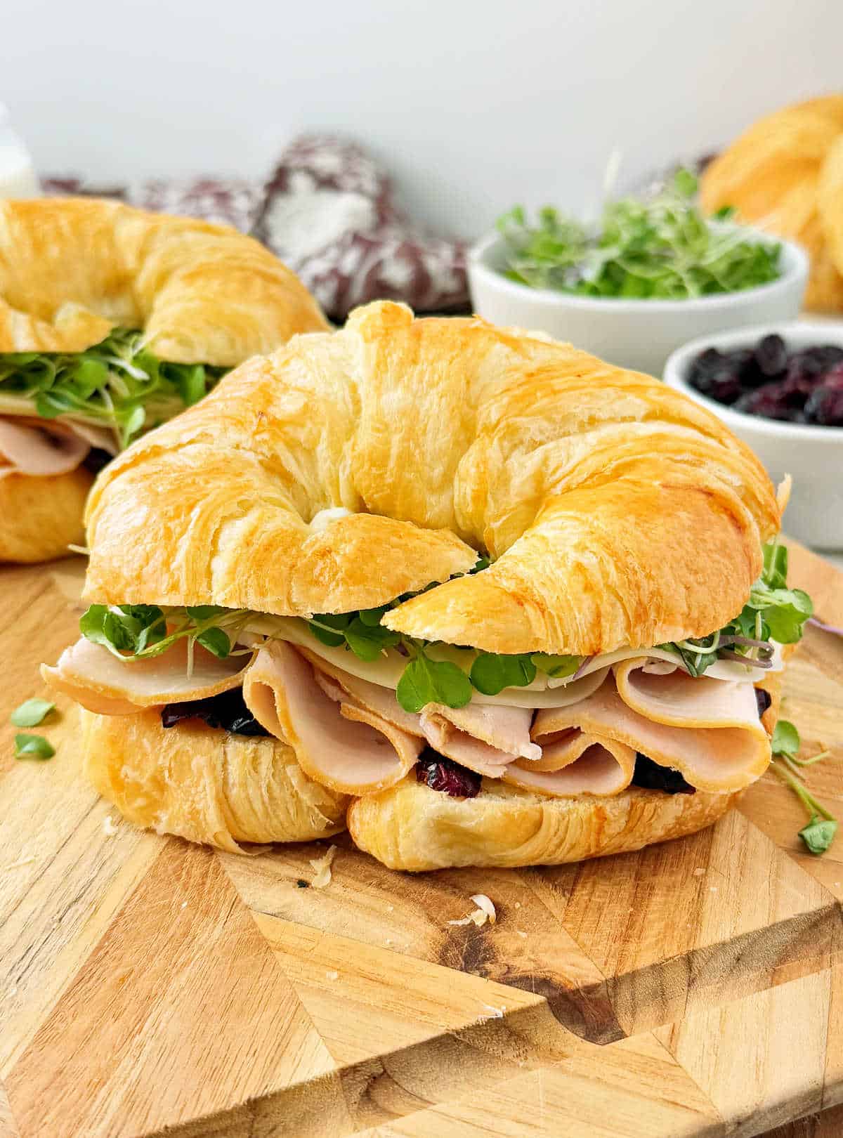 turkey croissant sandwich on cutting board.