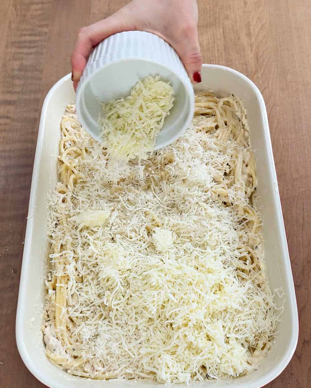 topping pasta with cheese.