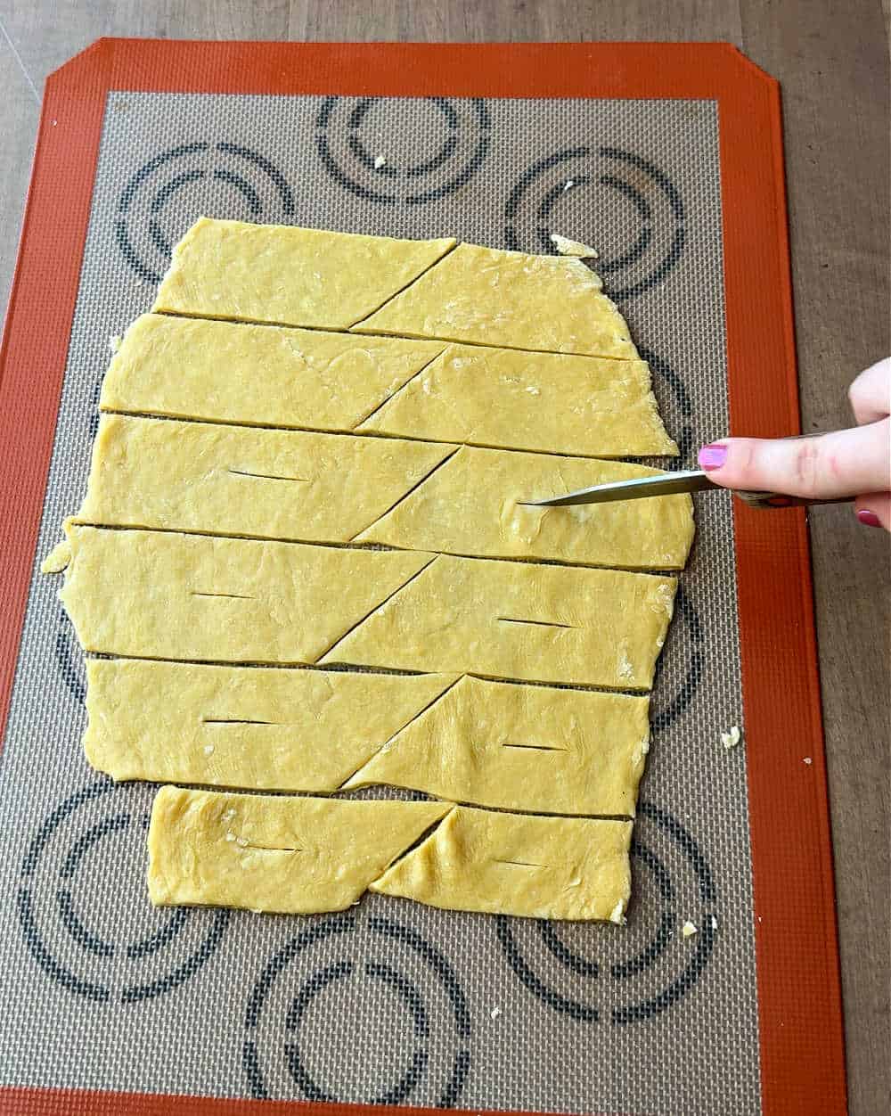 cutting cheregi dough with knife.