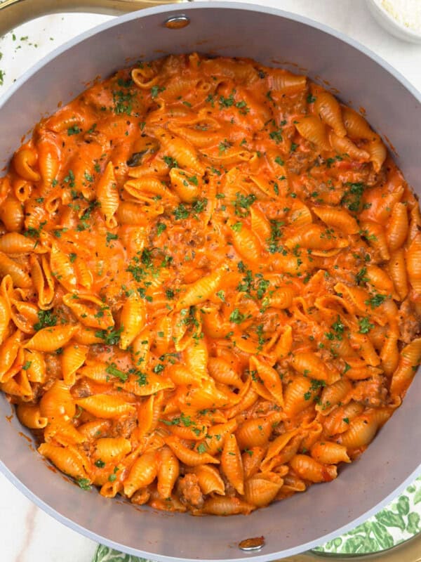 one pot creamy sausage and shells pasta in Dutch oven.