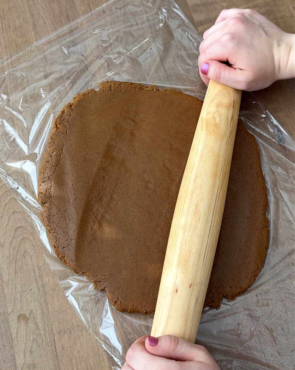 rolling dough on plastic wrap.