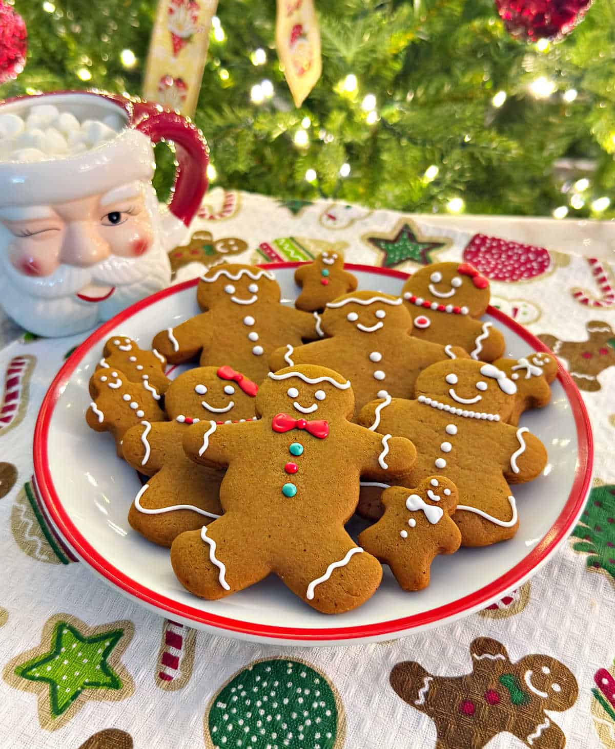 plate of gingerbread men cookies by Christmas tree.