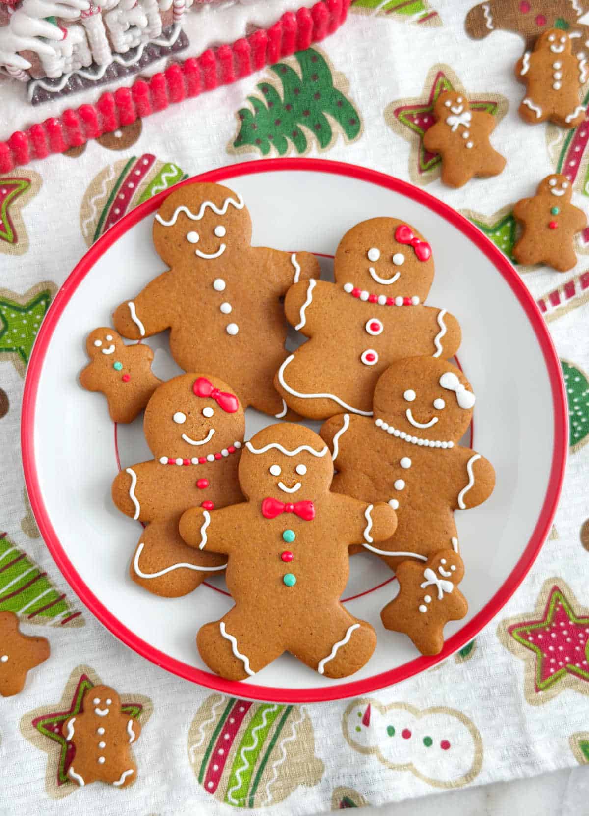 Plate of cut out gingerbread cookies decorated with royal icing.