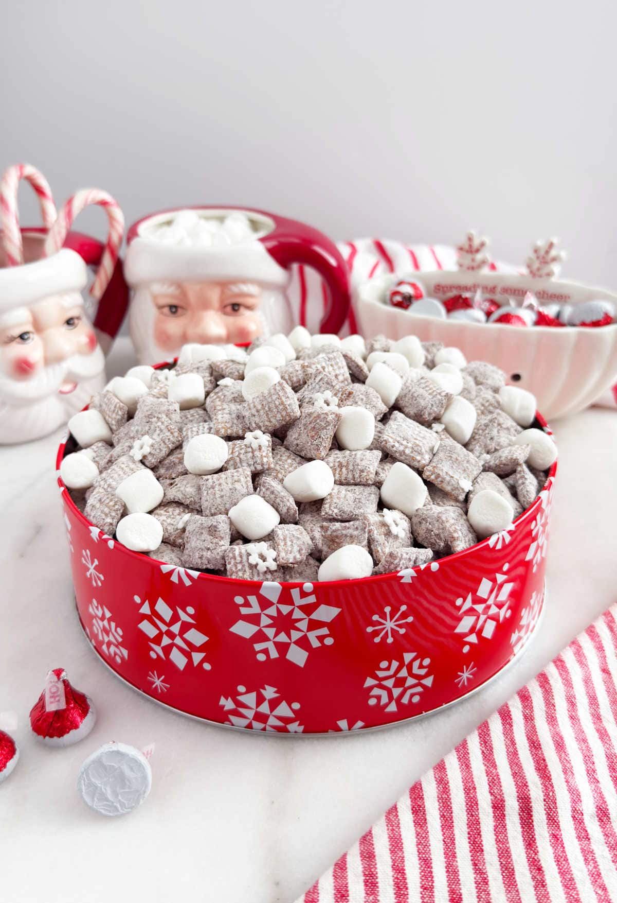 hot chocolate muddy buddies aka puppy chow in a red tin with marshmallows.