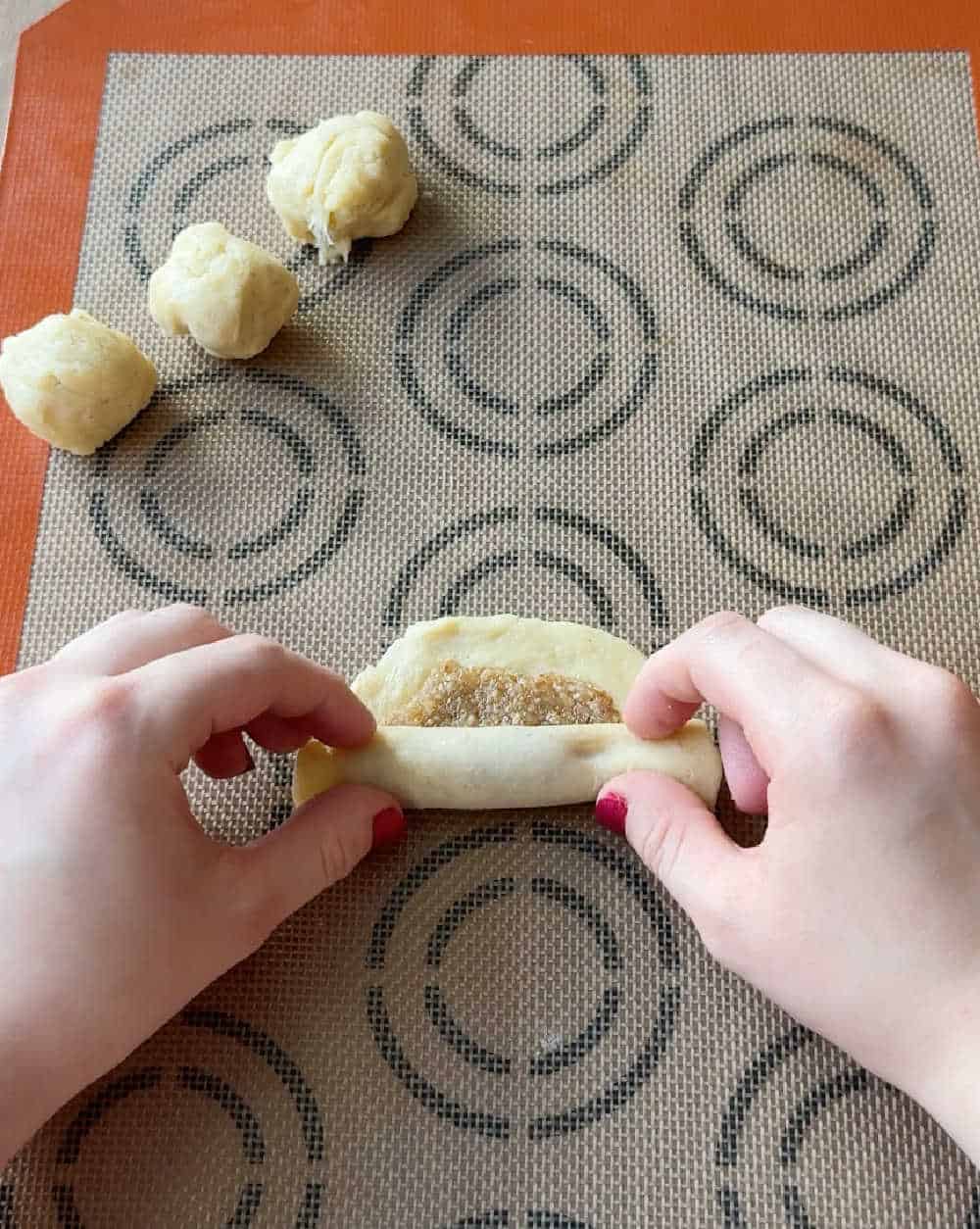 rolling up cookies with hands.