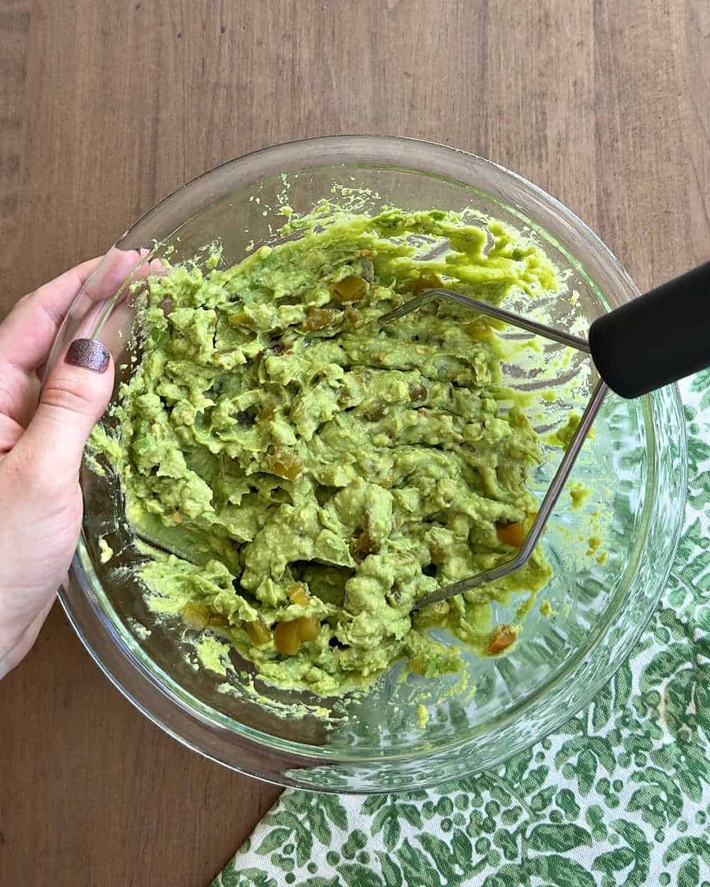 mashing chiles into the dip.