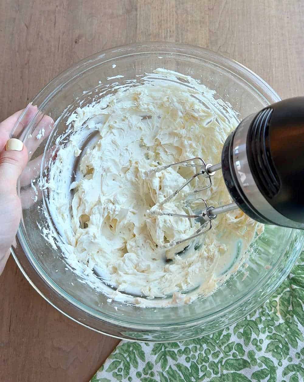 mixing cream cheese with hand mixer.