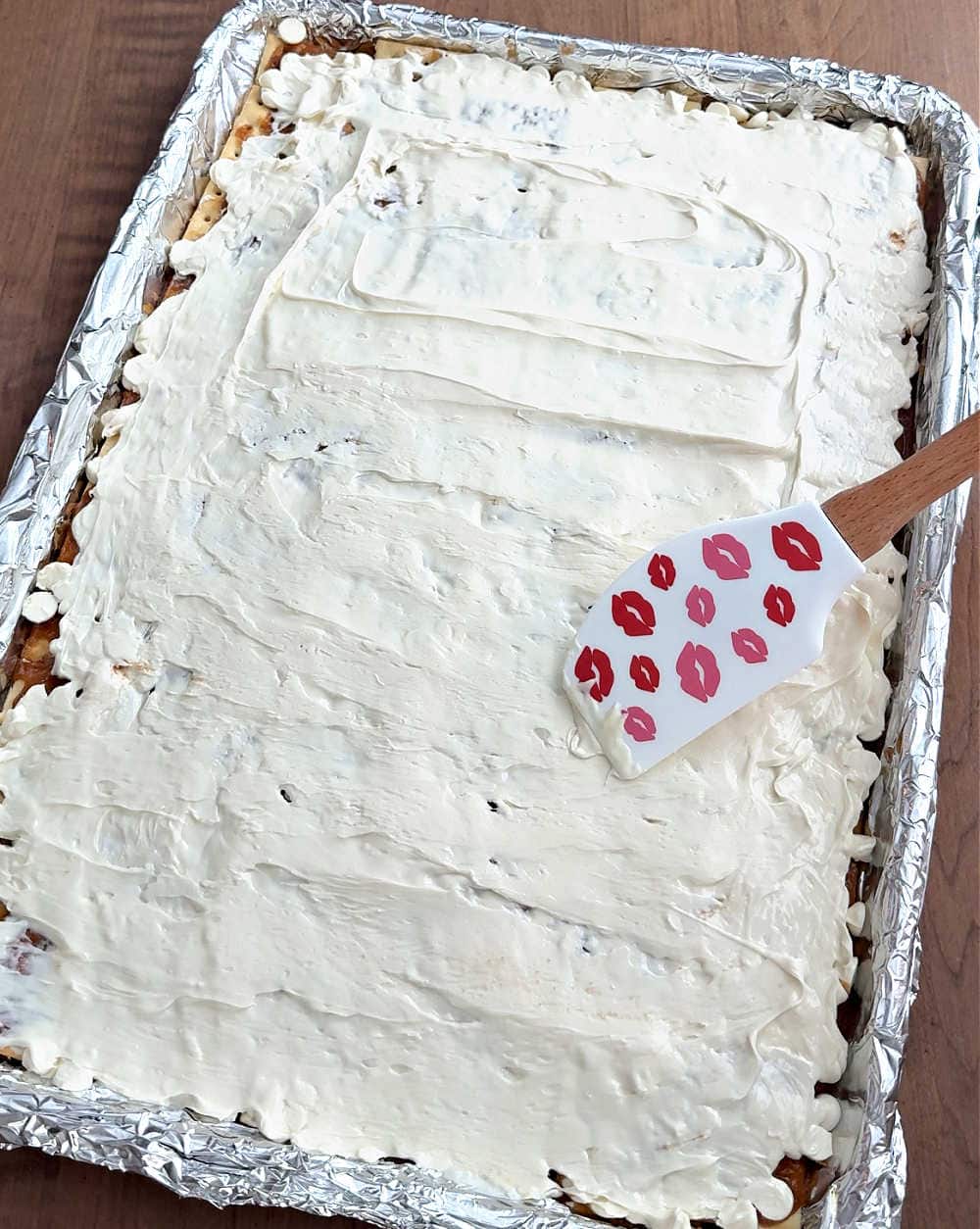 smoothing chocolate layer with spatula.