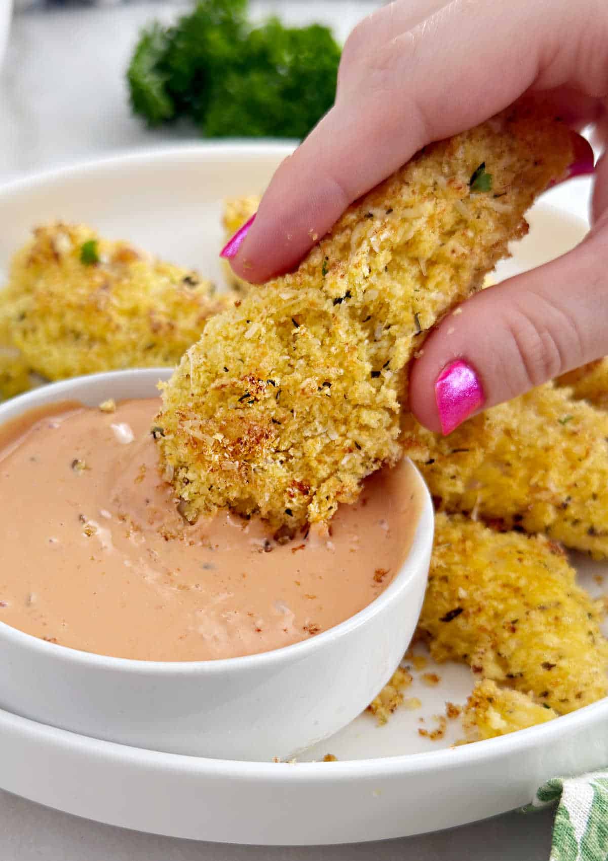 dunking chicken in dipping sauce.