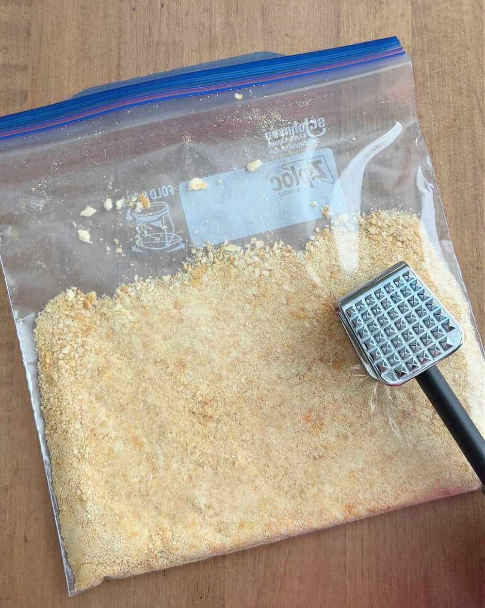 crushing buttery crackers in freezer bag.
