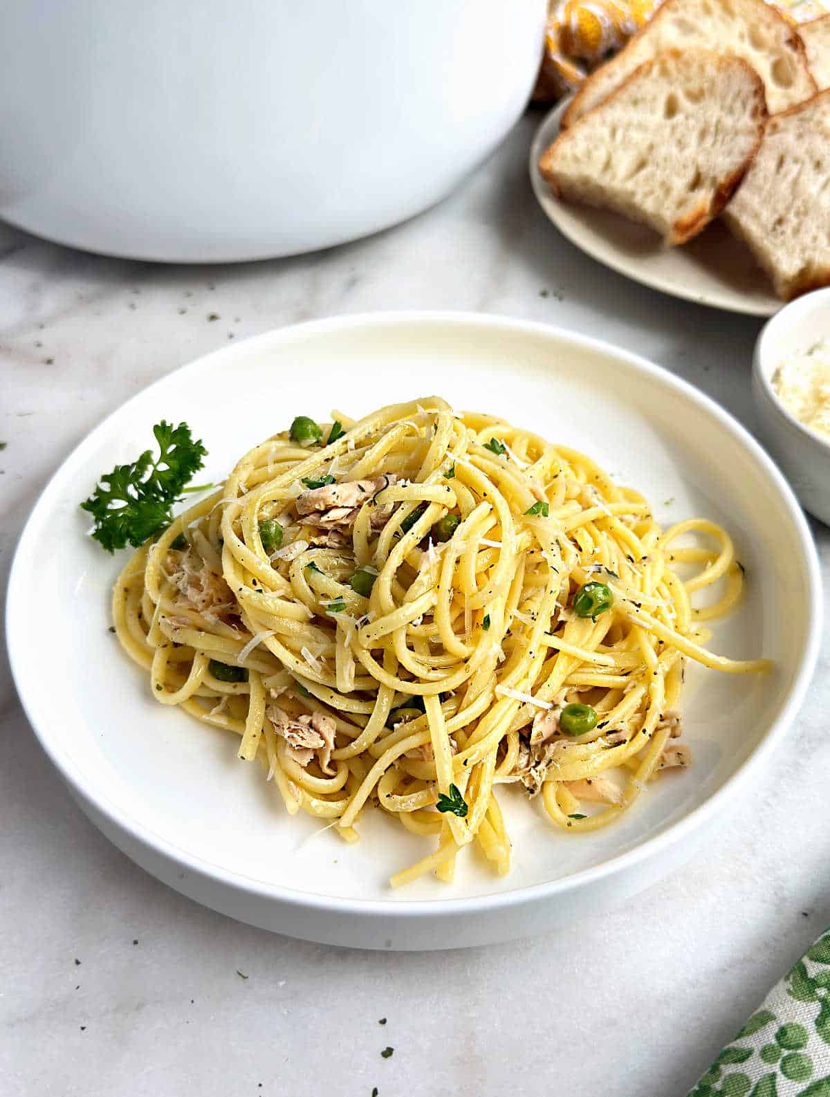 tuna pasta with peas on a white plate.