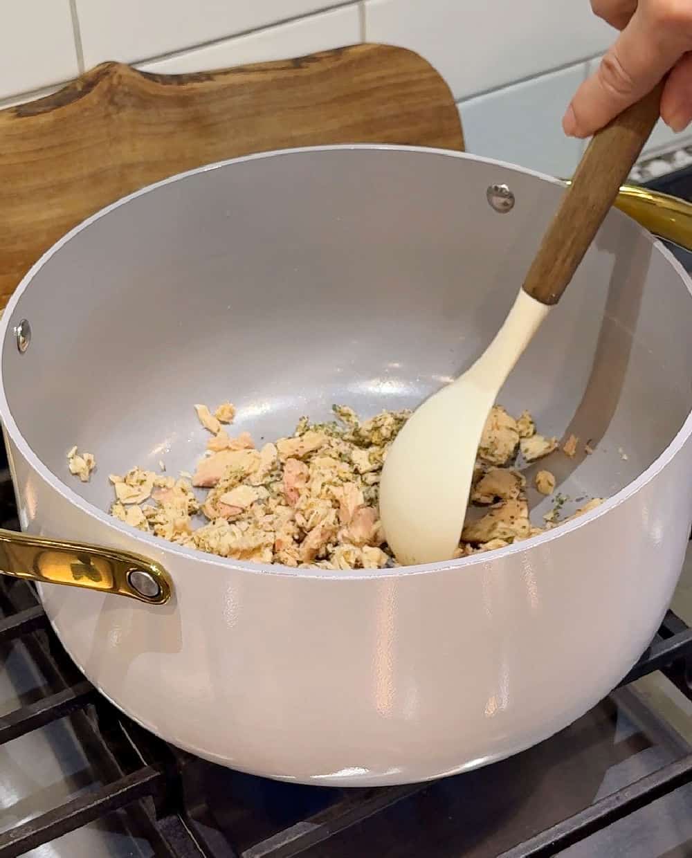 stirring seasoned tuna in pot.