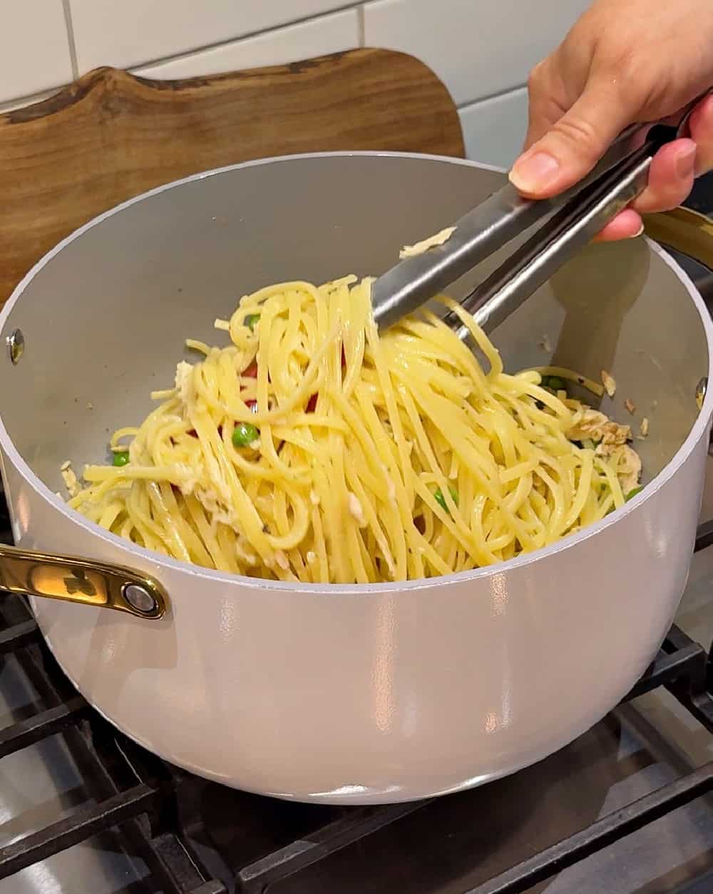 tossing pasta with kitchen tongs.