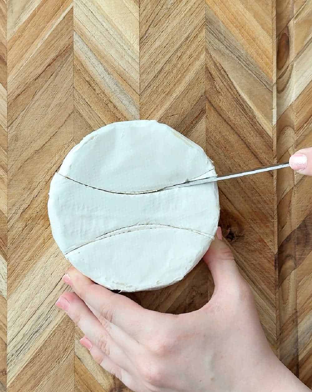 cutting brie into thirds.