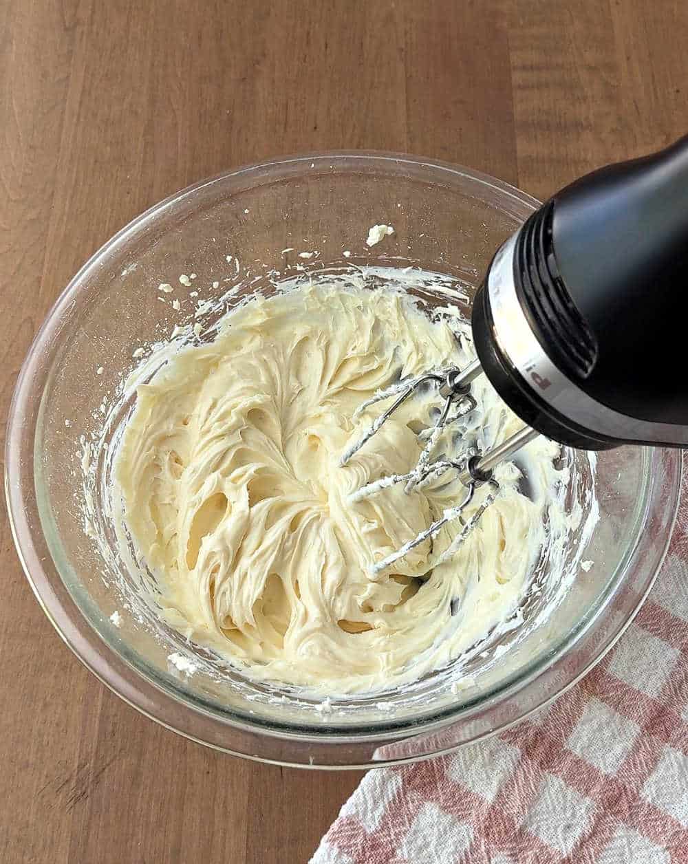 mixing cream cheese in bowl with mixer.