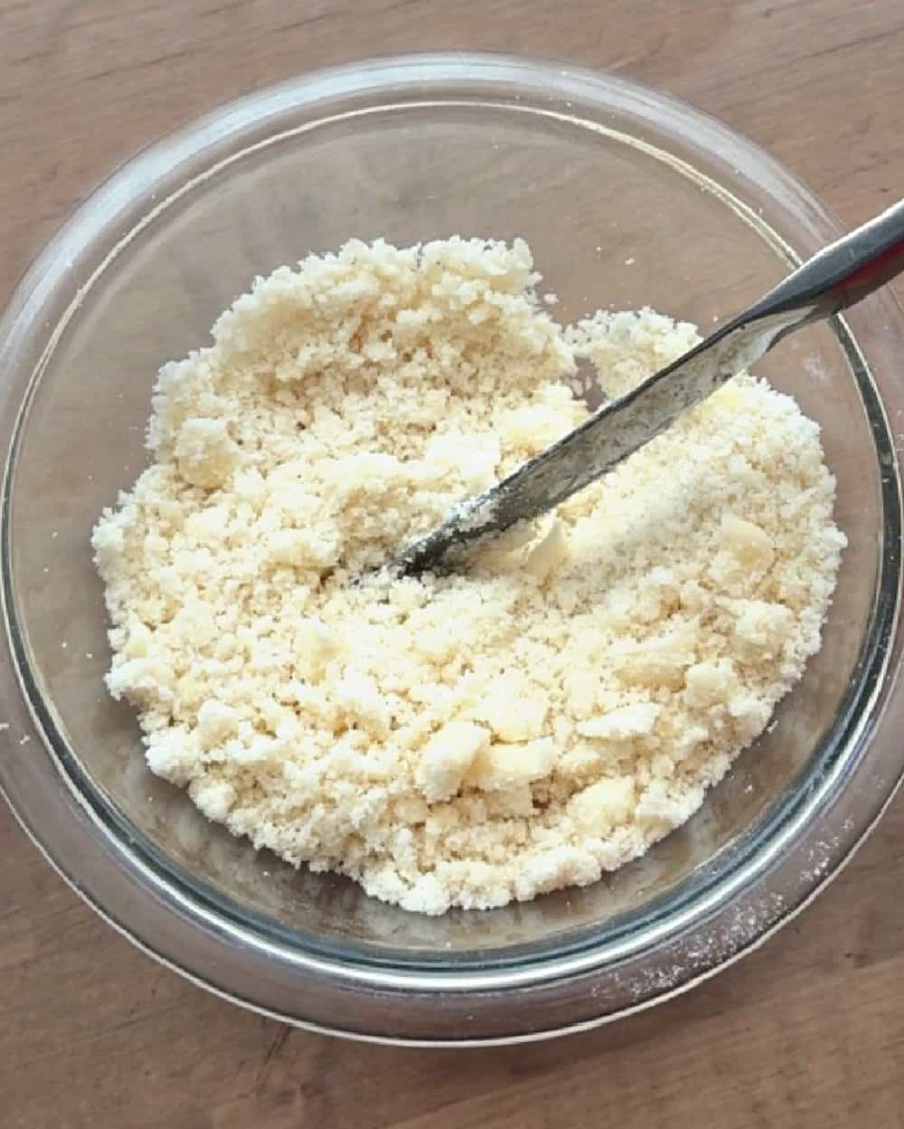cutting butter into flour and sugar with knife.