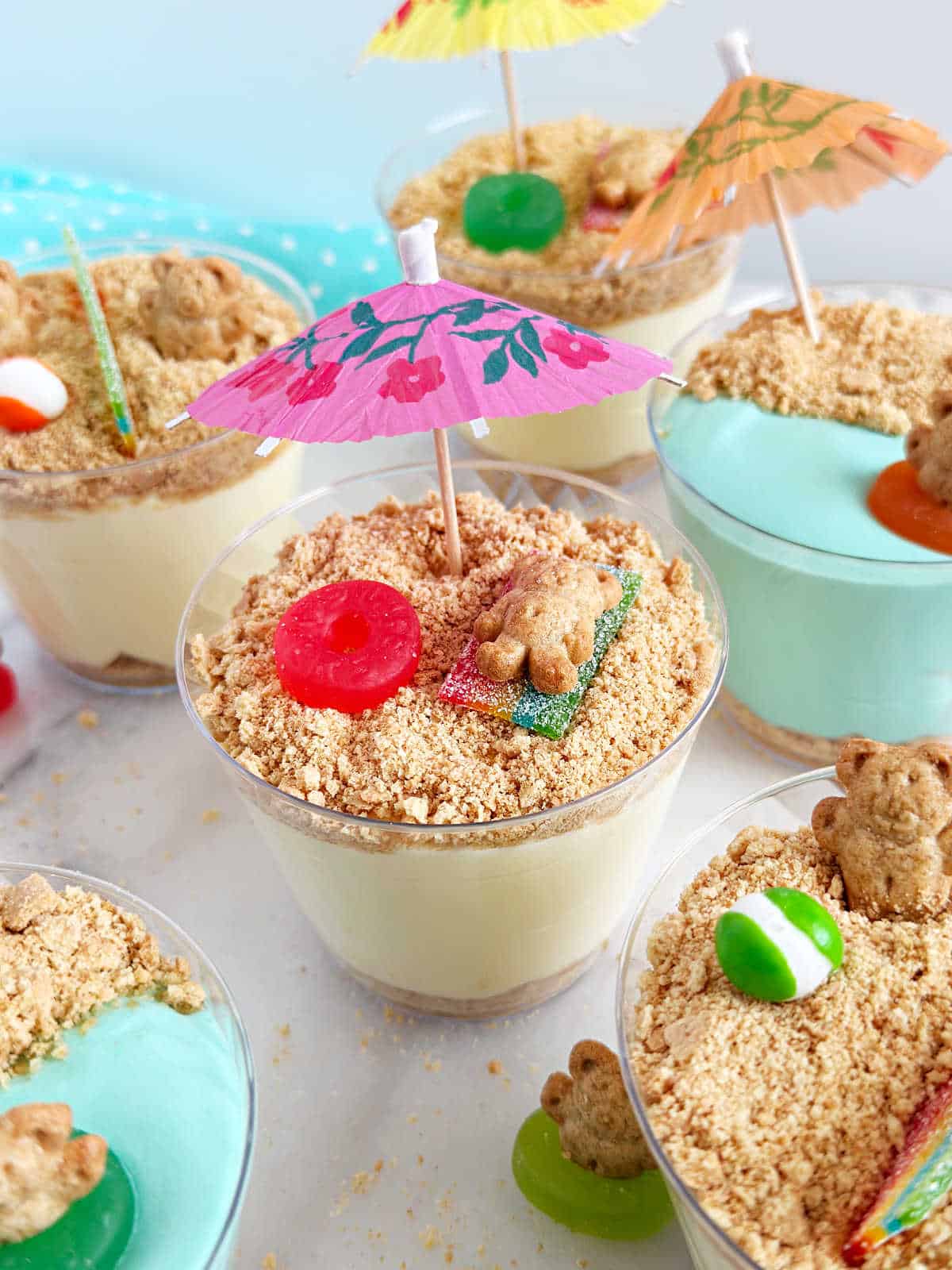 beach pudding cups with jello pudding and graham crackers and teddy graham on towel.