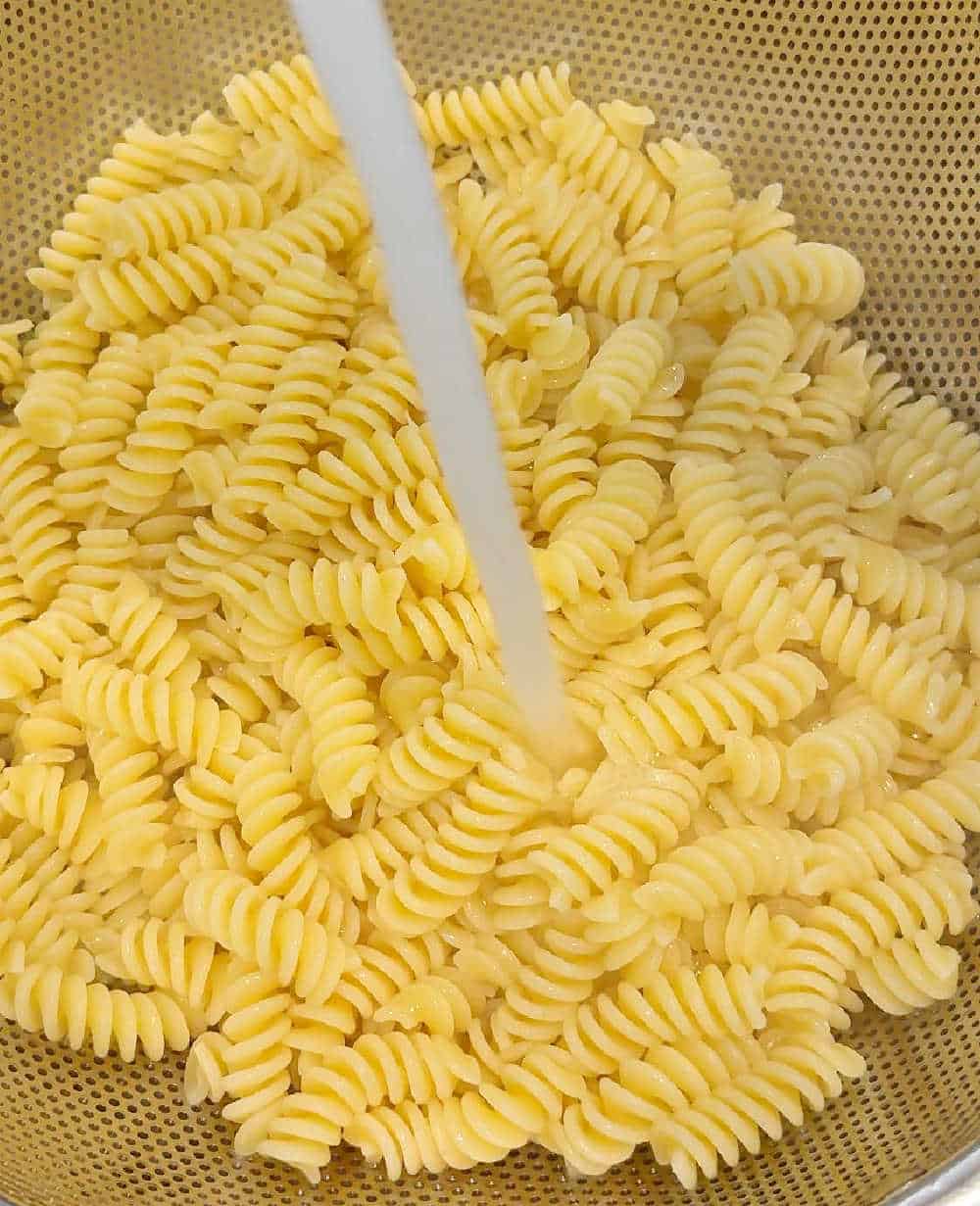 rinsing pasta with water.