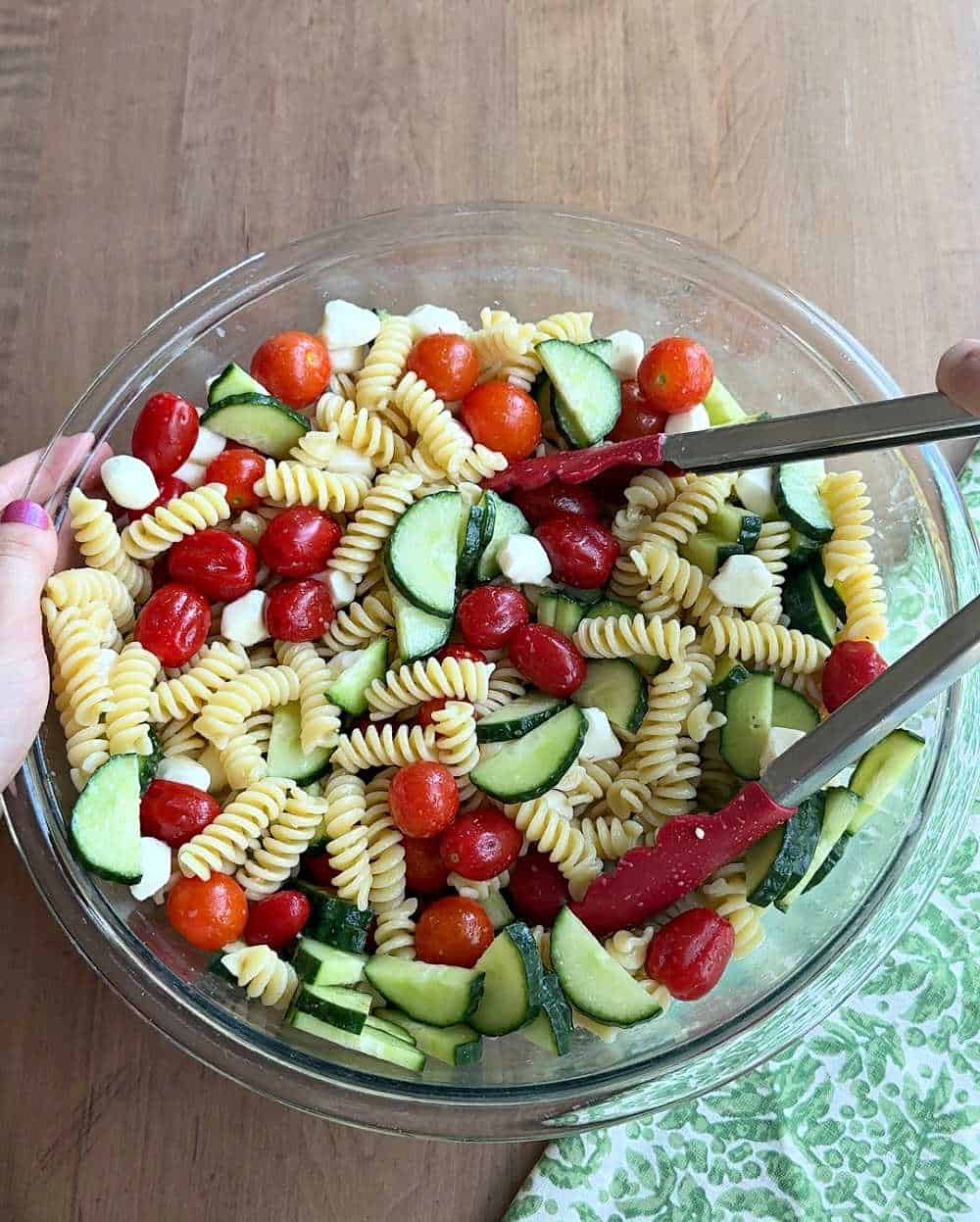 tossing salad ingredients in bowl.