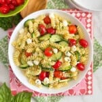 bowl of cucumber tomato pasta salad with mozzarella balls.