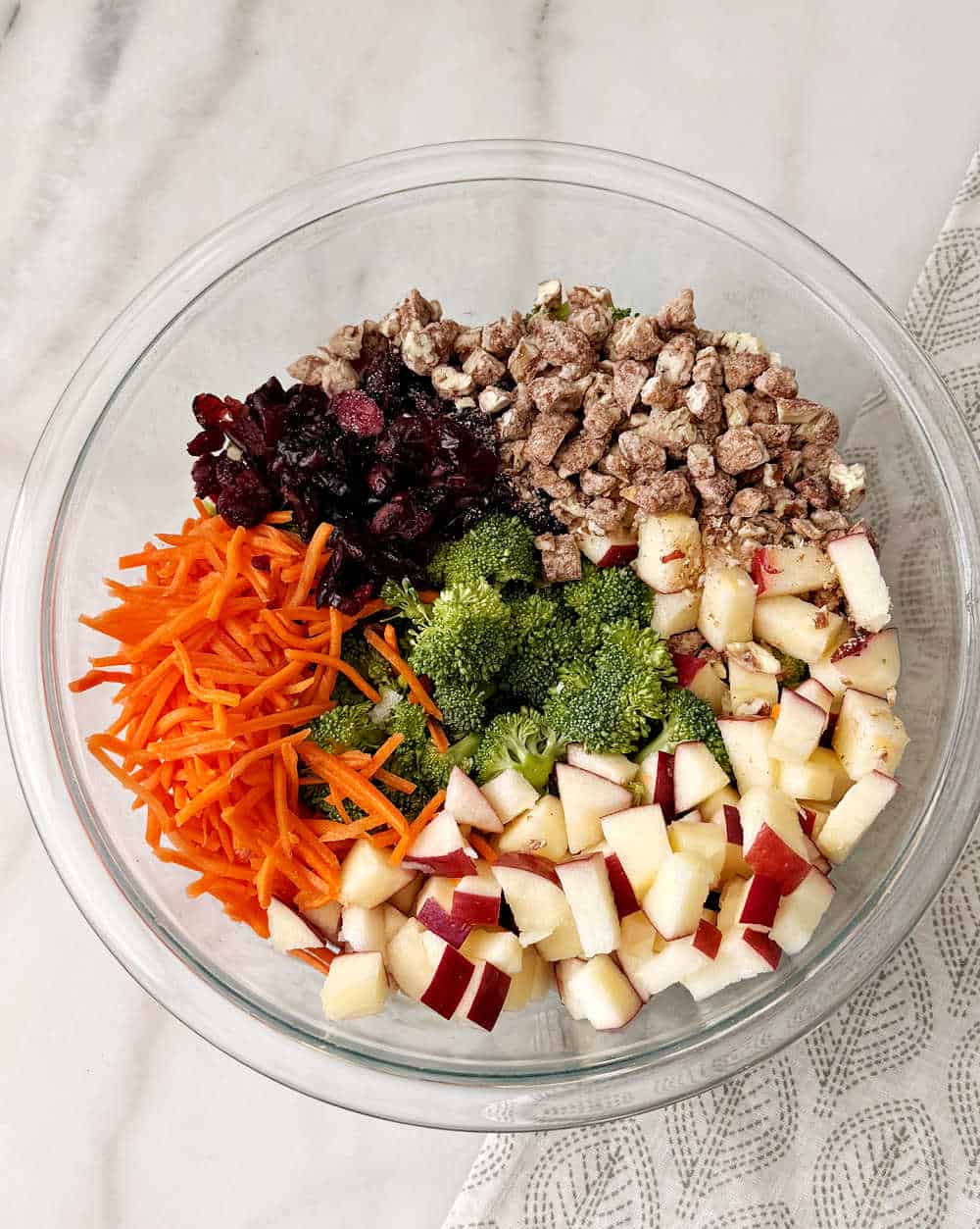 adding salad ingredients to large bowl.