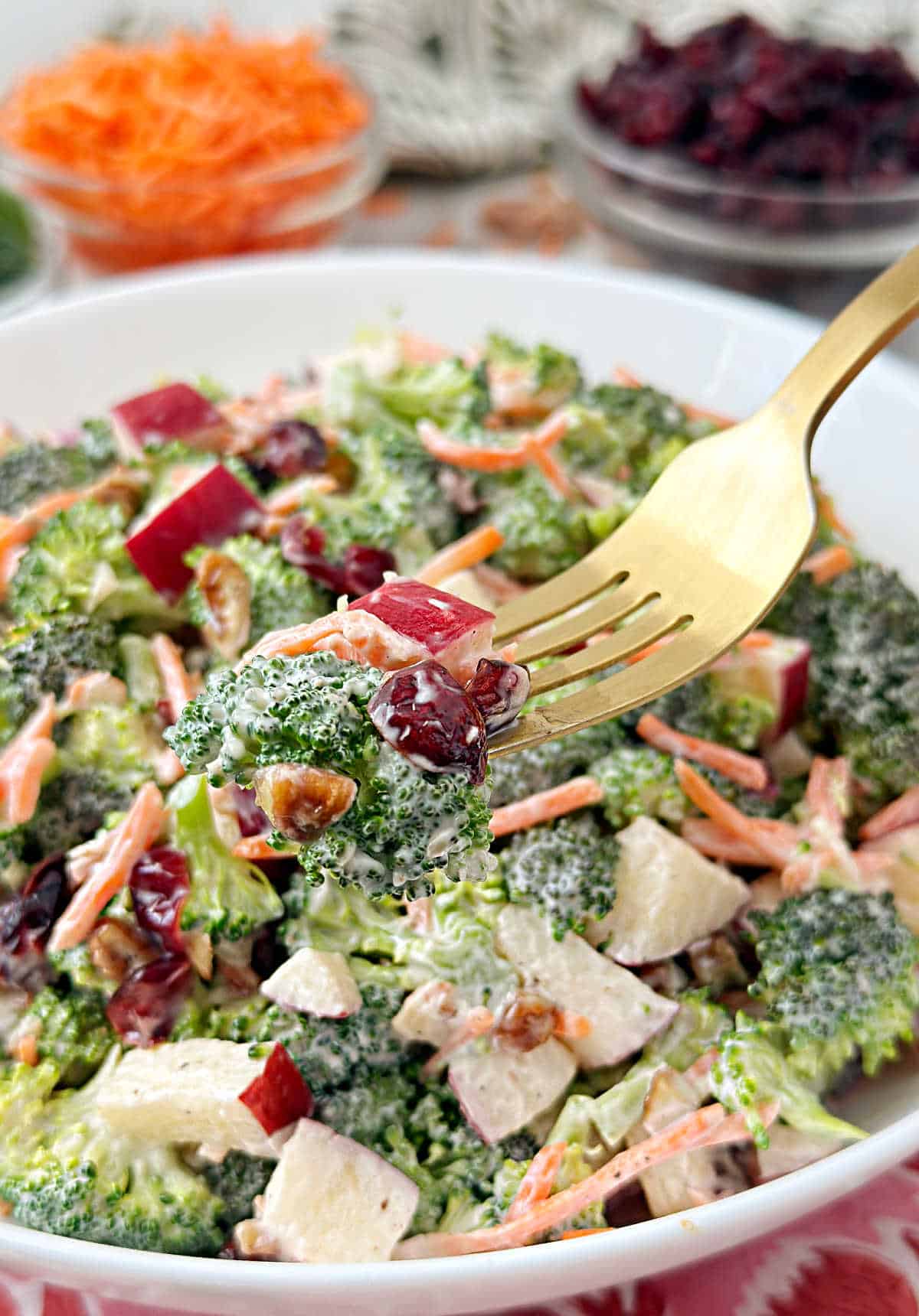 broccoli salad with craisins on a gold fork.