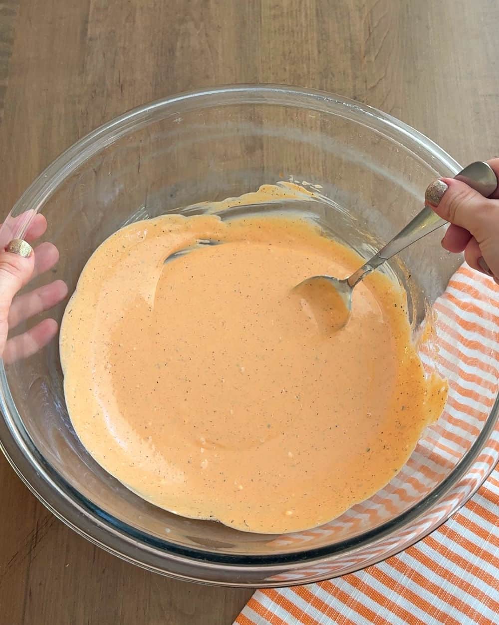 mixing dressing in glass bowl.