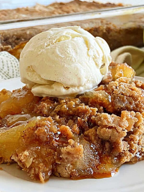 apple dump cake with ice cream on a plate.