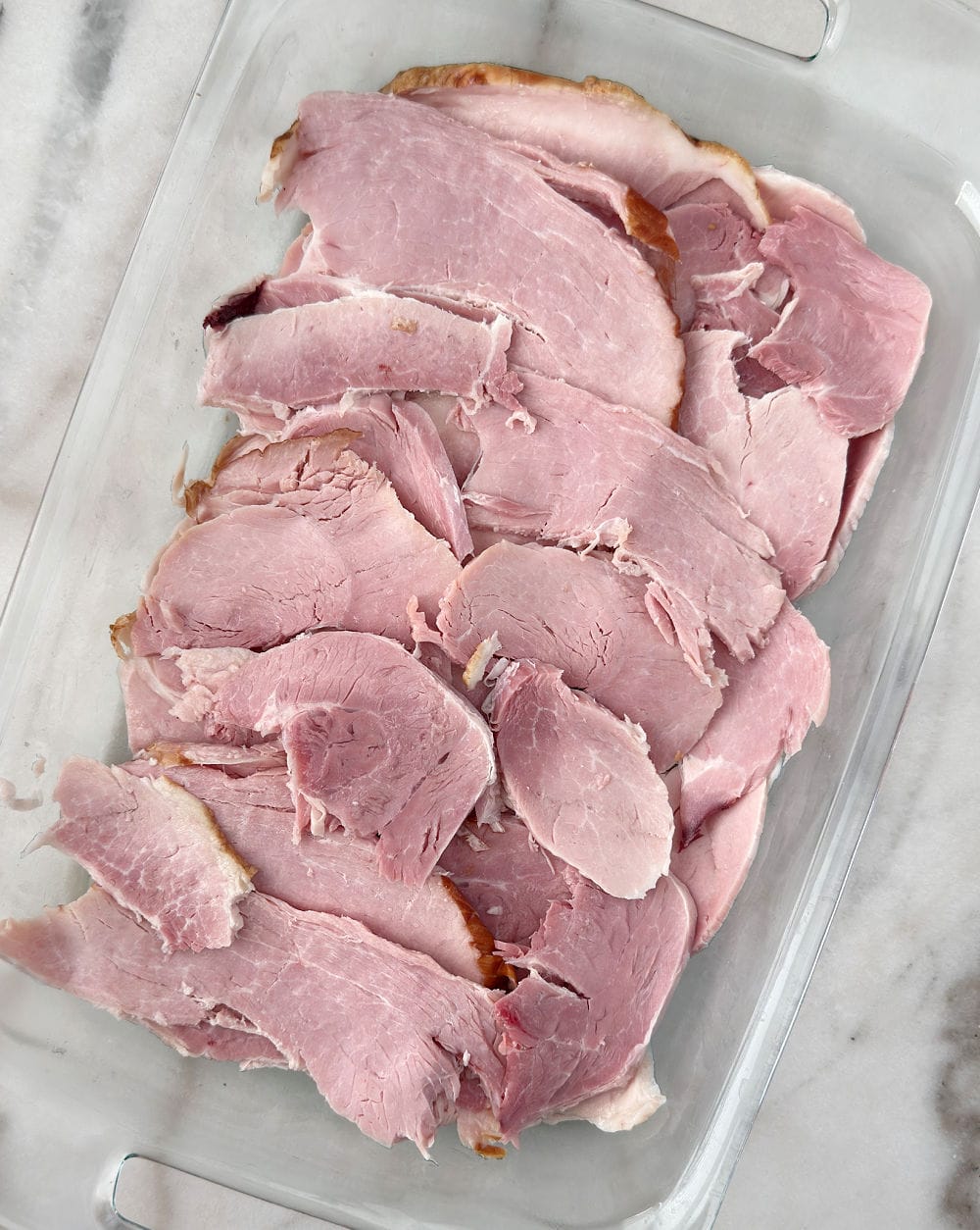 slices of ham in casserole dish.
