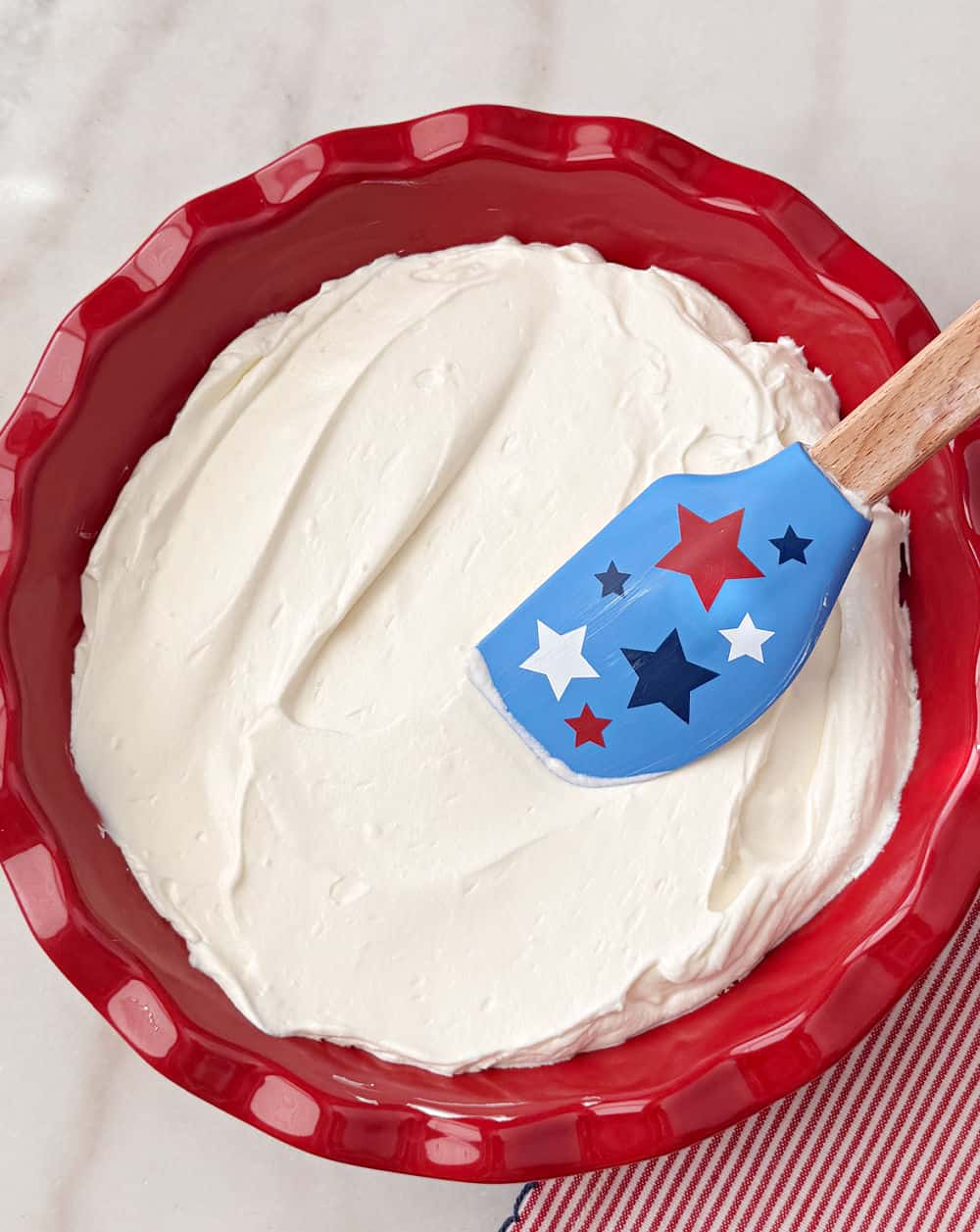 spreading creamy base in pie dish with star spatula.