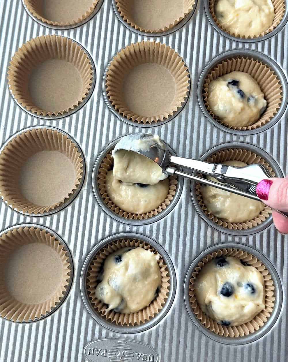 scooping batter into muffin tin.