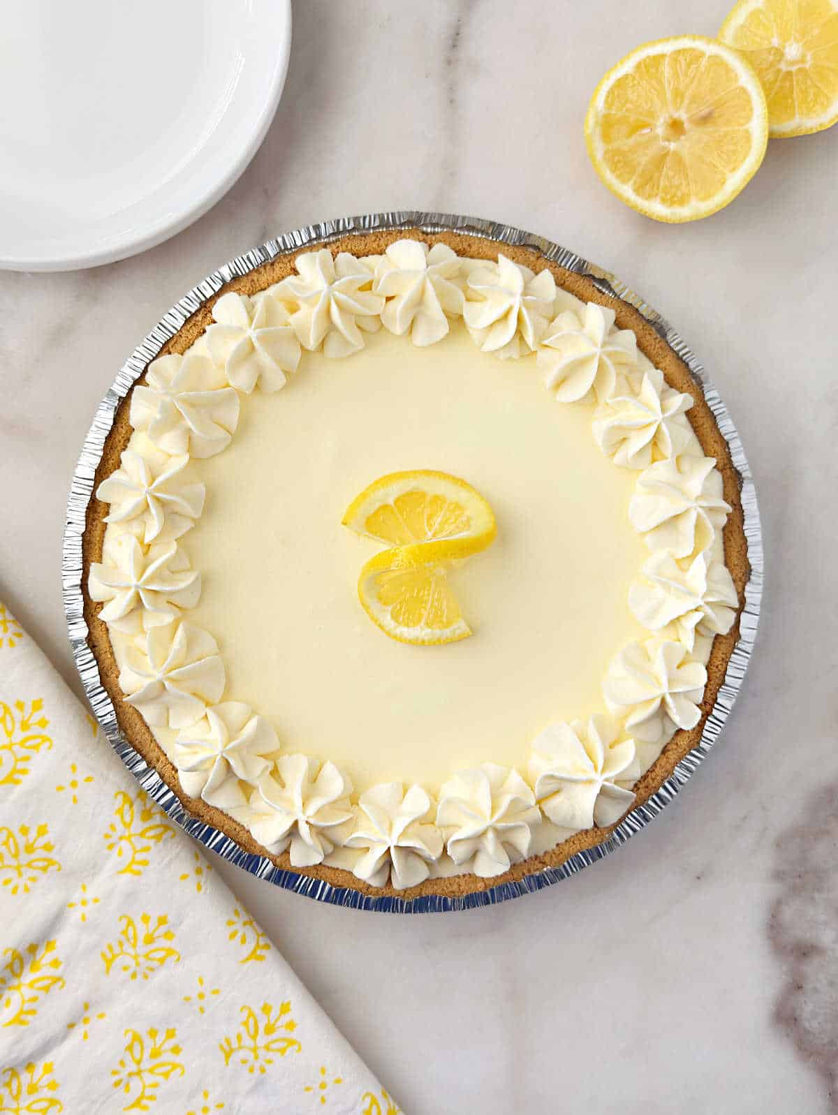 no-bake lemon jello pie with lemon twist and whipped cream flowers.