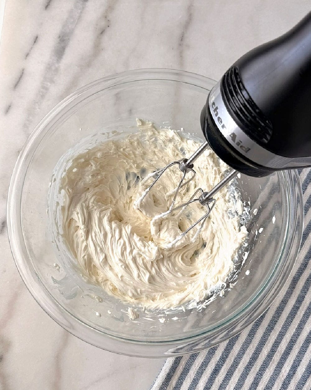 mixing cream cheese with electric mixer.