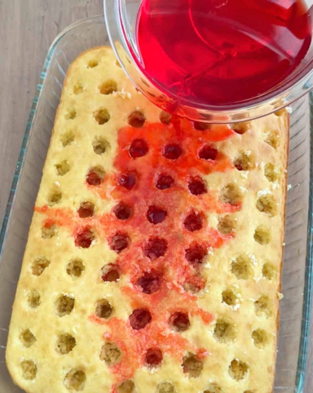 pouring jello over cake.
