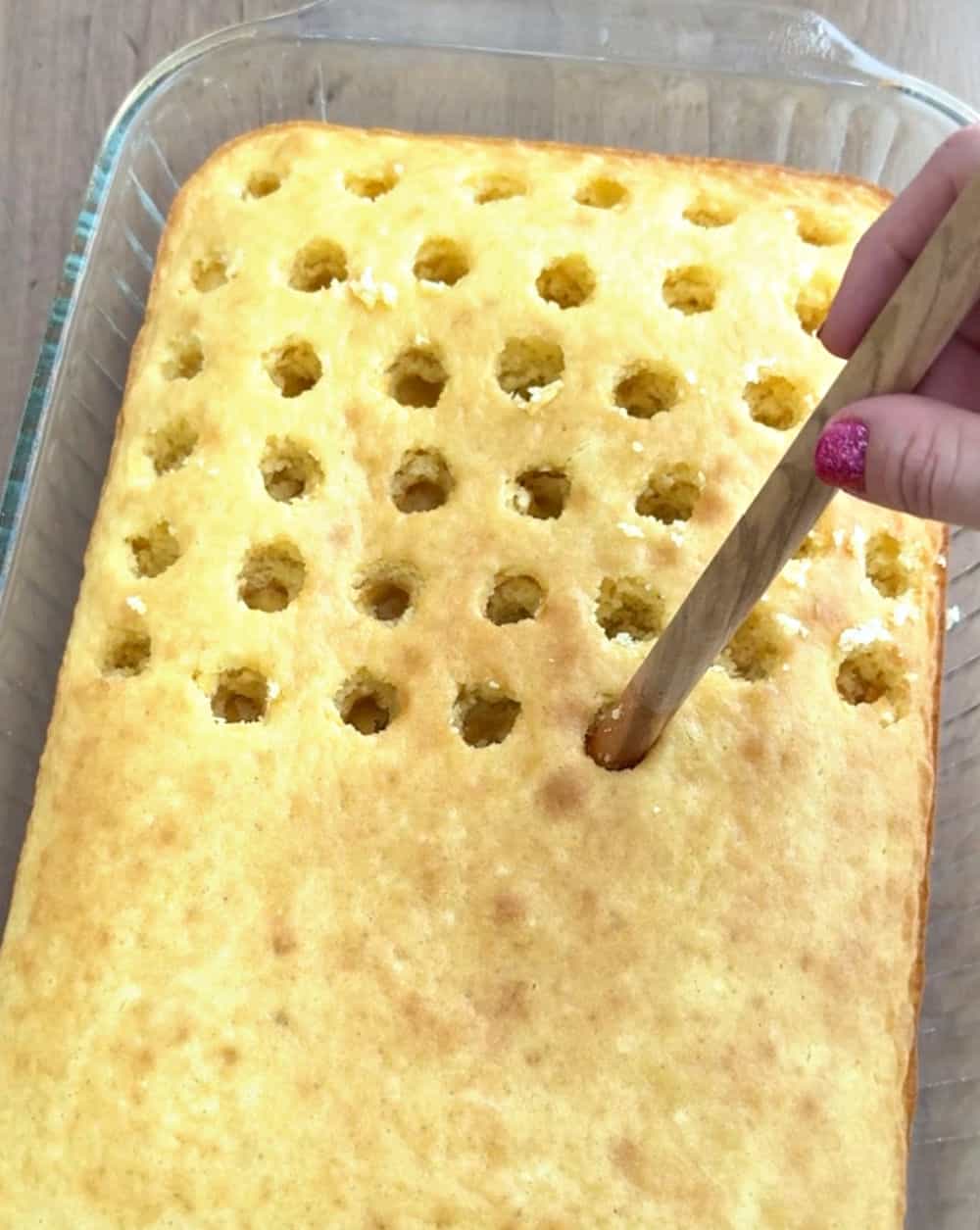 poking holes with wooden spoon.