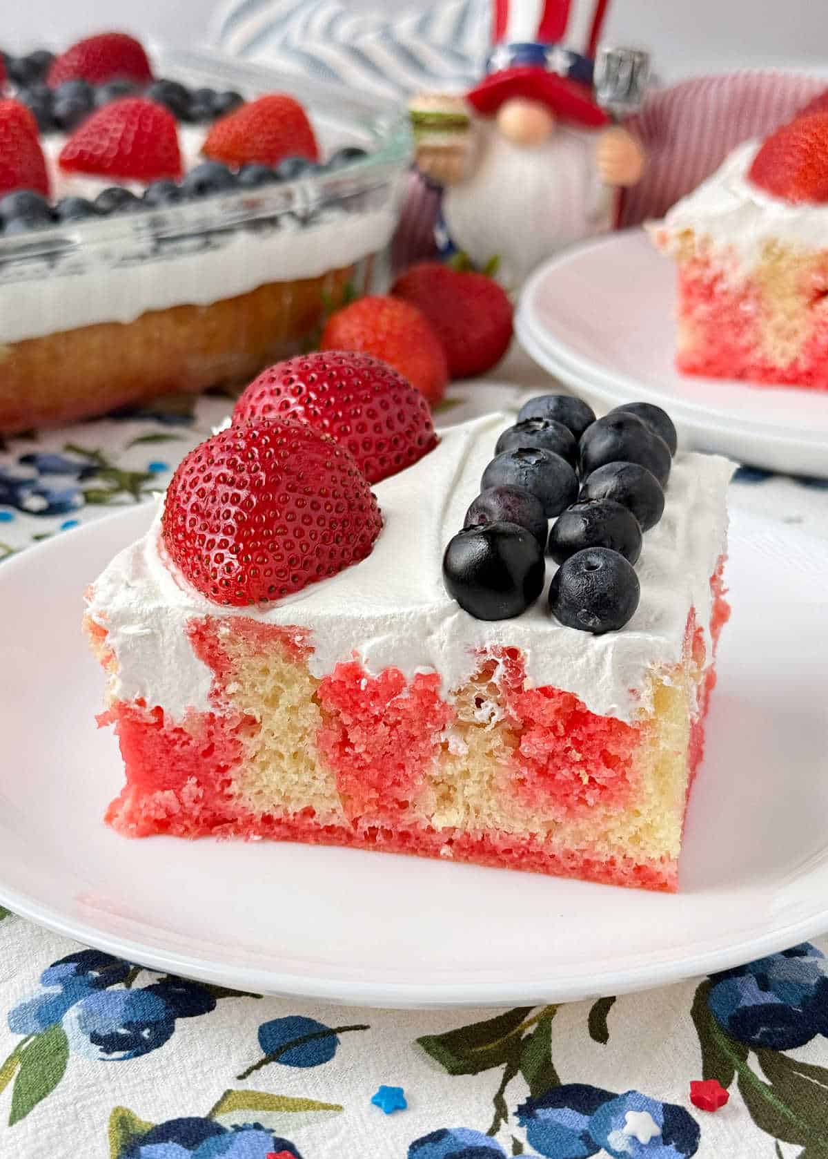 slice of red, white and blue poke cake on a plate.